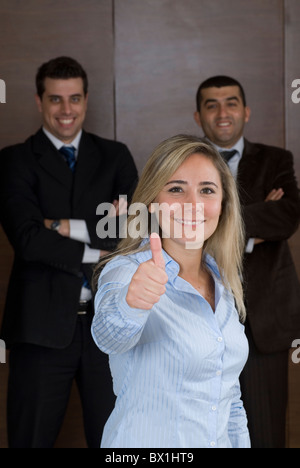 Business donna pollice in alto e due uomini d'affari in background all'interno di office Beirut Libano Medio Oriente Foto Stock