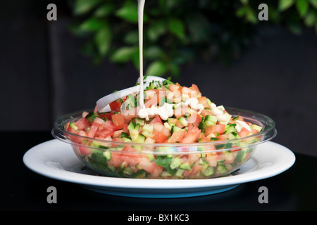 Insalata fresca di cubettato di pomodoro, cetriolo, erbe e il succo di limone e salsa di tahina Foto Stock