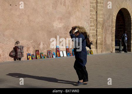 Un marocchino uomo che porta un agnello durante il festival annuale di Fete du Mouton in Marocco o altrimenti noti come Eid al-Adha Foto Stock