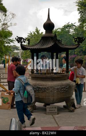 Bruciare incenso all'ingresso al Monastero Po Lin Foto Stock