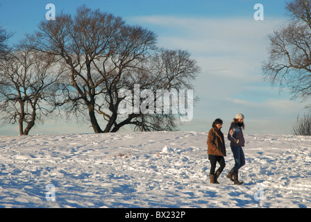 Due donna godendo di una passeggiata nella neve su Calton Hill, Edimburgo, Scozia, Regno Unito. Foto Stock