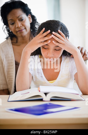 Madre consolante frustrato figlia facendo i compiti di scuola Foto Stock