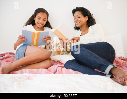 Madre e figlia la lettura a letto Foto Stock