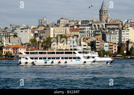 I turisti in una Turyol vista vedere crociera sul Bosforo dalla Golden Horn, Istanbul, Turchia. Torre di Galata in background Foto Stock