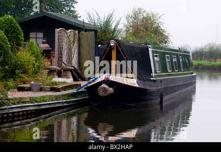 Canal scena chiatta ormeggiata dalla strada alzaia e tettoia in legno con giardini realizzati per la chiatta galleggiante Foto Stock