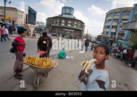 Ragazza a mangiare una banana in Piazza Area, Addis Abeba, Etiopia Foto Stock