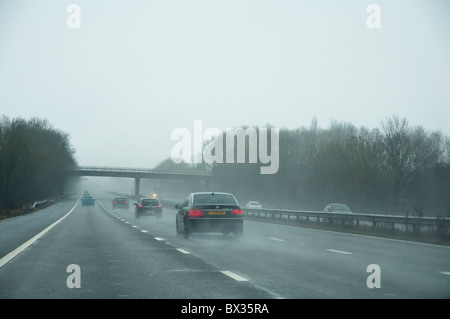 Punto di vista di driver di autostrada su un inverni grigia giornata con scarsa visibilità. Regno Unito. Foto Stock