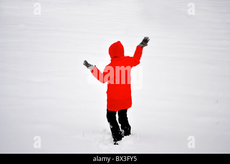 Ragazza nella neve con un mantello rosso Foto Stock