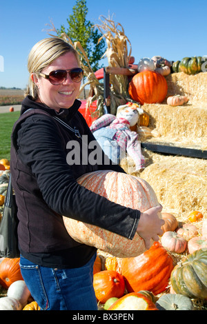 Donna scegliendo una zucca in un orto di zucche in Fruitland, Idaho, Stati Uniti d'America. Signor Foto Stock