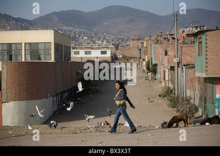 Una giovane donna puntoni attraverso San Juan de Miraflores, un sobborgo di Lima, Perù. Foto Stock