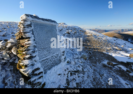 Neve e ghiaccio in crosta Gough Memorial al vertice del bordo di estensione su Helvellyn nel Lake District inglese Foto Stock