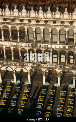 I camerieri presso il Caffè Quadri stand tra i tavoli e le sedie al sole del mattino in attesa dei primi clienti della giornata. Venezia Italia Foto Stock