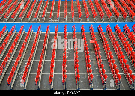 File di sedili rosso a Londra Olympia, uno con la base del sedile verso il basso Foto Stock