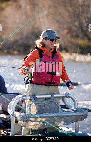 Donna di Pesca a Mosca Report di Pesca da una barca sul fiume Arkansas, vicino Salida, Colorado, STATI UNITI D'AMERICA Foto Stock