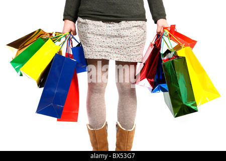 Giovane donna che trasportano confezioni regalo, scatole di cartone, di diverse dimensioni e colori in diverse borse per lo shopping. Foto Stock