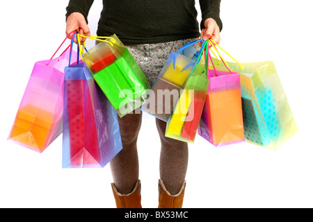 Giovane donna che trasportano confezioni regalo, scatole di cartone, di diverse dimensioni e colori in diverse borse per lo shopping. Foto Stock