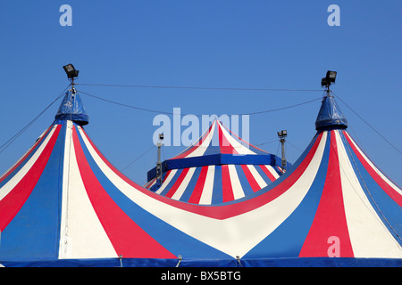 Tenda del circo sotto il cielo azzurro strisce colorate rosso bianco Foto Stock