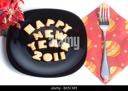 La piastra nera con carattere di biscotti a forma di forcella e decorazione di Natale isolato su bianco Foto Stock