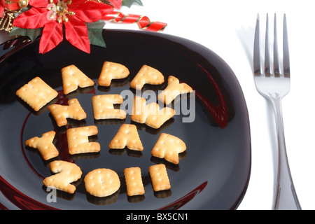 La piastra nera con carattere di biscotti a forma di forcella e l anno nuovo decorazione isolato su bianco Foto Stock