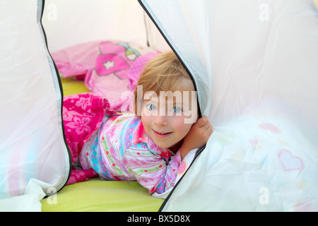 Ragazza in tenda da campeggio giacente felice su camp tenda Foto Stock