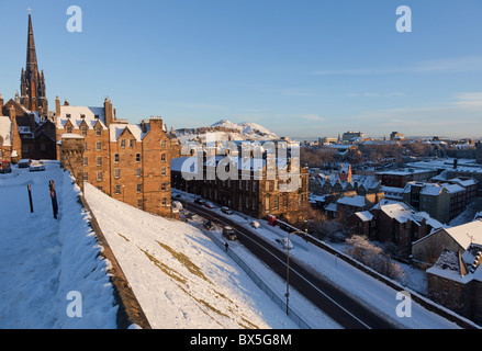 Vista sulla vecchia Edimburgo Castello dalla spianata per aurthurs sedile, tappezzate in neve al sole al mattino Foto Stock