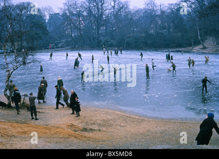 Persone il pattinaggio sul ghiaccio presso il locale stagno durante terribilmente freddo inverno 1962/3 Foto Stock