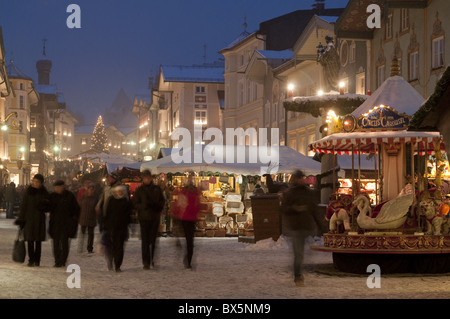 Mercatino di Natale con bancarelle e persone a Marktstraße al crepuscolo, Bad Tolz città termale, Baviera, Germania, Europa Foto Stock