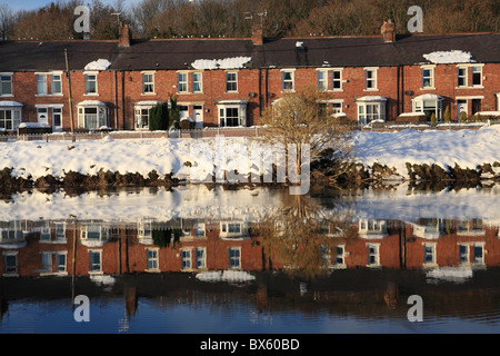 Vista sud, una riga o una terrazza di case riflessa entro il fiume usura Fatfield, Washington, Tyne and Wear, England, Regno Unito Foto Stock