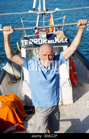 Pescatore in barca da pesca Foto Stock