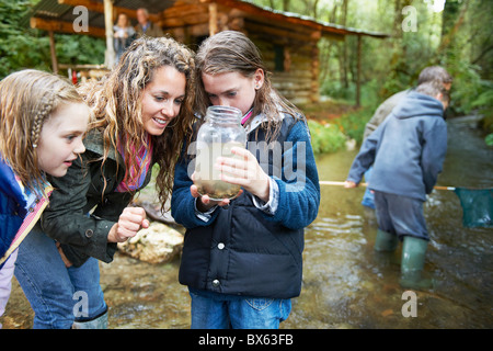 Famiglia in cerca di insetti nel vasetto di marmellata Foto Stock