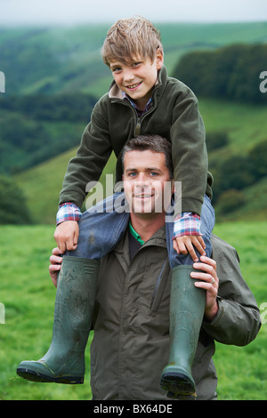 Padre figlio dando una piggy back nel campo Foto Stock