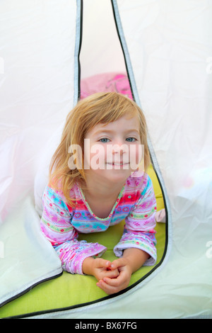 Ragazza in tenda da campeggio giacente felice su camp tenda Foto Stock