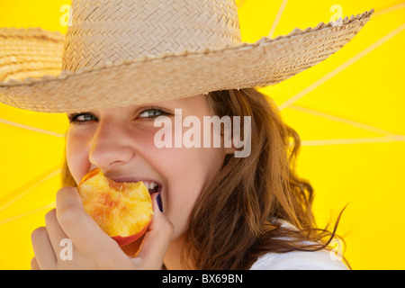 Bella donna sorridente e mangiare la frutta Foto Stock