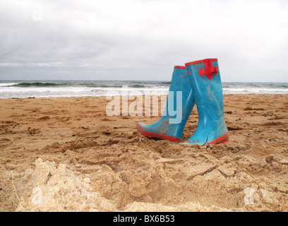 Abbandonato coppia di gomma Stivali in gomma sulla spiaggia Foto Stock