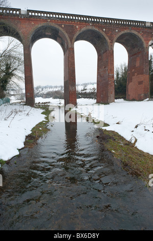 Neve minacciose nuvole nel cielo offuscare la terribilmente freddo fiume Darent Foto Stock