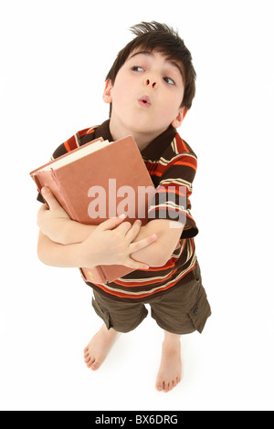 Adorabili e sette anni di Francese antico american boy in piedi con grande libro su sfondo bianco. Foto Stock