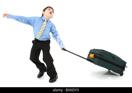 Adorabili e sette anni di Francese antico american boy in tuta lottando con grande valigia su sfondo bianco. Foto Stock