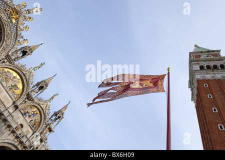 Il campanile e la Basilica di San Marco, Piazza San Marco, con bandiera veneziana, Venezia, Sito Patrimonio Mondiale dell'UNESCO, Veneto, Italia Foto Stock