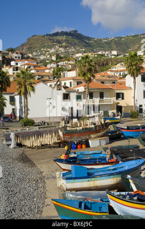 Sale di asciugatura cod (bacalhau) e barche da pesca nella piccola costa sud porto di Camara de Lobos, Madeira, Portogallo, Atlantico Foto Stock