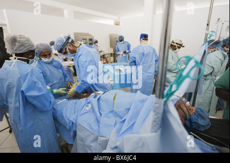 Medico americano di eseguire l'intervento chirurgico, la gamba del paziente di frattura, Gennaio 2010 terremoto, Ospedale Generale di Port au Prince, Haiti Foto Stock