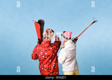 Vista posteriore del giovane sportivo puntando verso qualcosa su sfondo blu Foto Stock