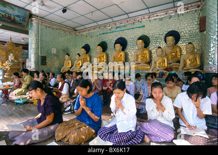 Le donne di pregare presso la Shwe Dagon Pagoda (Shwedagon Paya), Yangon (Rangoon), Myanmar (Birmania), Asia Foto Stock