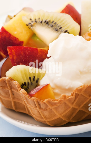 Gelato alla crema con insalata di frutta come primo piano in un wafel Foto Stock