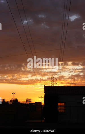 Torri di trasmissione e linee di alimentazione stagliano contro un tramonto spettacolare sky. Stanislaus County, California, U.S.A. Foto Stock