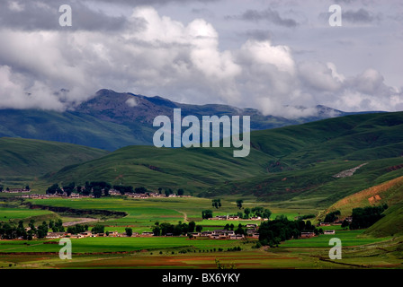 Valle con le aziende agricole e le gamme della montagna in background,sichuan,Cina Foto Stock