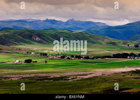 Valle con le aziende agricole e le gamme della montagna in background,sichuan,Cina Foto Stock