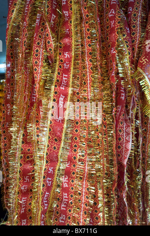 Rosso e oro tinselled panni per devoti indù la visita di un tempio, Guwahati, Assam, India, Asia Foto Stock