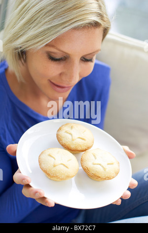 Donna di mangiare carne macinata torte Foto Stock