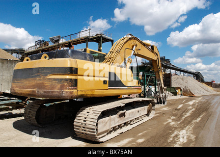 Grande escavatore caterpillar al giorno aggregati a materiali di costruzione e impianto di riciclaggio a sud-est di Greenwich London REGNO UNITO Foto Stock