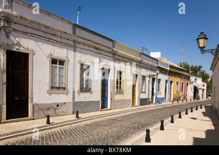 Una fila di case tradizionali davanti una strada di ciottoli nella città murata di Faro, Algarve, Portogallo, Europa Foto Stock